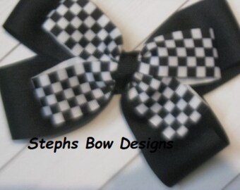 Könnte beinhalten: Eine schwarz-weiß karierte Schleife mit dem Text "Stephs Bow Designs". Die Schleife hat ein klassisches Karomuster in Schwarz und Weiß mit einer einfarbigen schwarzen Basis. Die Schleife ist wahrscheinlich handgefertigt.