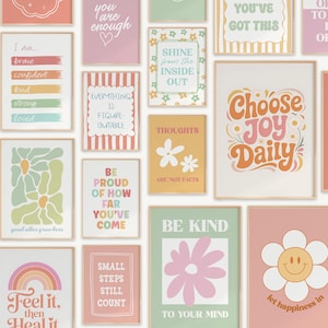 May include: A collection of framed art prints with inspirational quotes and floral designs. The prints feature phrases like "Choose Joy Daily," "Be Kind," and "Shine from the Inside Out." Colors include pink, orange, green, and white.