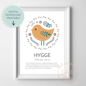 May include: A printable art print with a yellow bird illustration surrounded by blue and orange flowers. The print includes the word "HYGGE" and its definition in Danish: "(HUE-guh) A warm feeling of cosiness and wellbeing. Being contented with life's simple pleasures, living in the moment and enjoying the everyday. Spending time with people you love, surrounded by warmth, good food & drink, and candlelight."