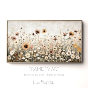 May include: A framed digital art print featuring a field of wildflowers in shades of white, yellow, and peach. The artwork has a soft, painterly style and is set against a neutral background. The frame is gold. Text at the bottom reads "FRAME TV ART".