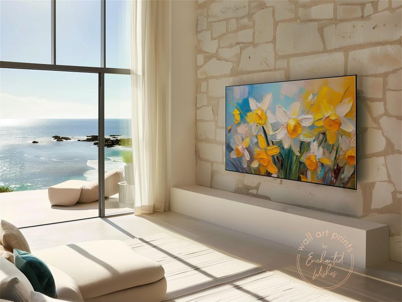 May include: A painting of yellow and white daffodils in a vase, with a blue and white background. The painting is hanging on a wall in a modern living room with a large window overlooking the ocean.
