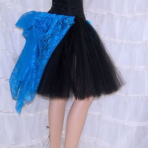 May include: A black tulle skirt with a blue lace overlay. The skirt is short and has a ruffled hem.