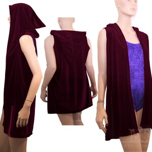 May include: A sleeveless burgundy velvet hooded vest with a long, flowing design. The vest has a deep hood and a relaxed fit.