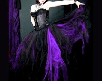 May include: A black tulle skirt with a purple tulle overlay. The skirt is long and flowing, and the purple overlay is gathered at the back. The skirt is worn by a woman with dark hair and makeup. The skirt is a gothic style and would be perfect for a Halloween costume or a dark and dramatic event.