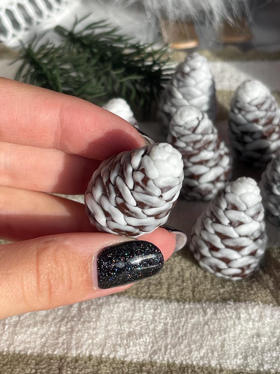Tiny sculpted pinecone soaps with snowy detail so realistic you'd feel bad using them — an artisan stocking stuffer that looks like it costs way more than $2.