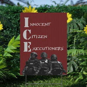 May include: A red sign with the text "INNOCENT CITIZEN EXECUTIONERS" in white. Below the text are three figures in black tactical gear. The sign is displayed outdoors, surrounded by green foliage and yellow flowers.