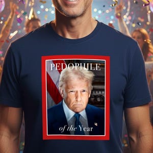 Może przedstawiać: Granatowa koszulka z portretem mężczyzny i napisem "PEDOPHILE of the Year" w czerwonej ramce. Tło przedstawia scenę imprezy z konfetti, balonami i ludźmi.