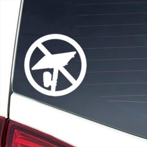 May include: A white vinyl decal featuring a circular prohibition sign with a diagonal slash across a stylized satellite dish icon. The graphic is applied to a dark glass surface, displaying a clear contrast between the white sticker and the background.