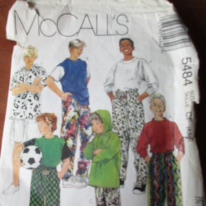 May include: McCall's sewing pattern number 5484 for boys' pants. The pattern shows five boys wearing different styles of pants, including a pair of black and white checkered pants, a pair of green and white patterned pants, a pair of black and white patterned pants, a pair of blue and white patterned pants, and a pair of red and blue patterned pants.