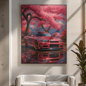 May include: A framed art print featuring a red sports car under a cherry blossom tree. The car is reflected in the water, with a mountain range in the background. The artwork has a vibrant color palette of pink, red, and gold.