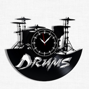 Op de afbeelding: Zwarte vinyl platen klok met een silhouet van een drumstel en het woord "DRUMS" in witte letters.