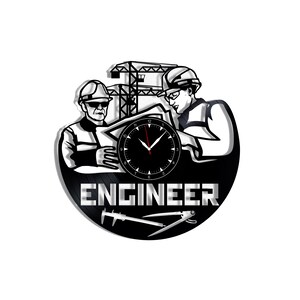 Könnte beinhalten: Eine runde Wanduhr mit einer schwarz-weißen Grafik von zwei Ingenieuren mit Schutzhelmen, die Baupläne vor einem Baukran betrachten. Das Wort ENGINEER steht in fetten Buchstaben unter einem Zifferblatt mit roten Zeigern.