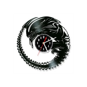 May include: A circular wall clock crafted from a black vinyl record, featuring a laser-cut silhouette of a xenomorph creature. The clock face is black with white numerals and white hour and minute hands, complemented by a thin red second hand.