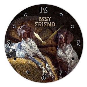 Könnte beinhalten: Eine runde Uhr mit schwarzem Hintergrund und einem braunen Holzrad in der Mitte. Das Zifferblatt der Uhr hat schwarze Zahlen und Zeiger. Zwei Deutsch Kurzhaar-Hunde sitzen auf Heuballen. Der Text "BEST FRIEND" ist auf dem Zifferblatt der Uhr gedruckt.