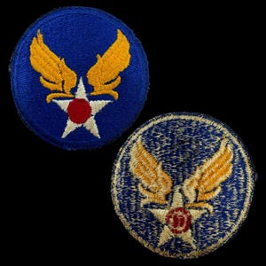 Peut inclure: Deux patchs brodés bleus avec des ailes jaunes et une étoile blanche avec un centre rouge. L'étoile du patch de gauche a un contour blanc, tandis que l'étoile du patch de droite a un contour doré.