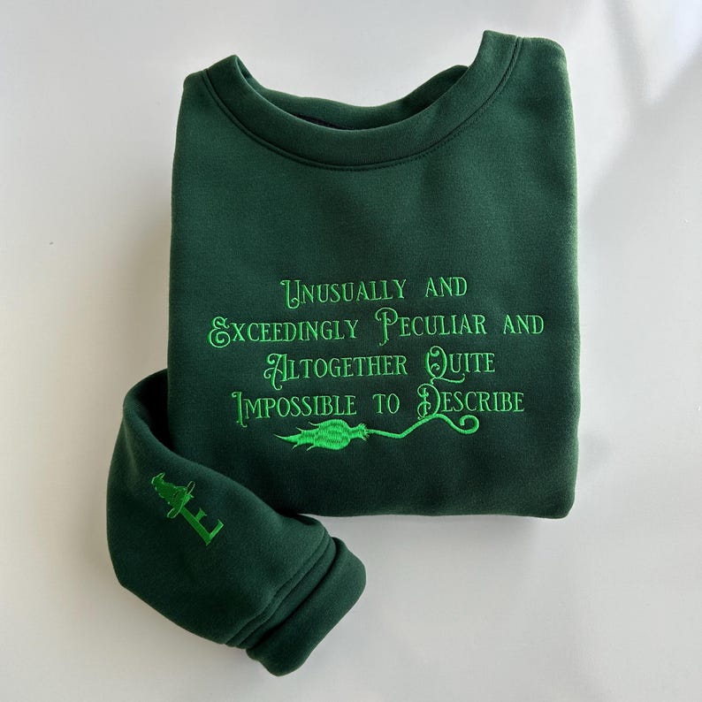 May include: Green sweatshirt with the text "Unusually and Exceedingly Peculiar and Altogether Quite Impossible to Describe" embroidered in green.