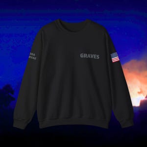 May include: Black sweatshirt with the word "GRAVES" printed on the front and a small American flag on the right sleeve.