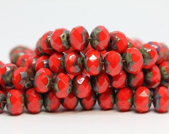 May include: A strand of red and green glass beads with a faceted finish. The beads are round and have a speckled appearance.
