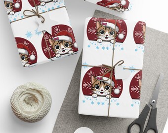 Puede incluir: Regalos envueltos con un patrón repetido de un gato de dibujos animados con un gorro de Papá Noel. Los regalos están atados con hilo y tienen etiquetas en forma de estrella. El papel de regalo tiene un fondo blanco con círculos rojos y copos de nieve azules.