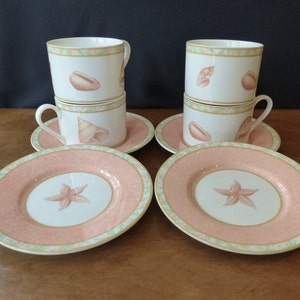 May include: Set of four pink and green teacups and saucers with a seashell and starfish design.