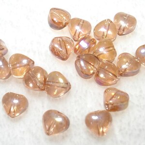 May include: A white ceramic mug with a black handle and the text "But First, Coffee" in a black, handwritten-style font. The mug is on a white surface.