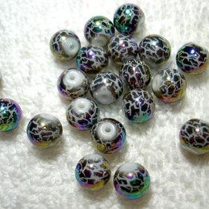 May include: A collection of iridescent glass beads with a white crackle finish. The beads are round and have a variety of colors, including blue, green, purple, and gold.