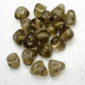 May include: A collection of translucent, olive-brown glass beads. Each bead has a rounded, irregular shape with a hole running through the center. The beads vary in size and have a glossy finish, suitable for jewelry making.