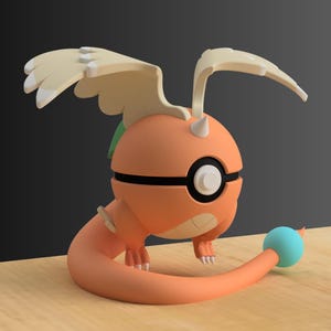 Op de afbeelding: Een 3D-geprinte oranje en witte figuur van een stripfiguur met vleugels, een lange staart en een blauwe bal aan het einde. Het personage heeft een zwarte band om het midden en een wit oog. De figuur staat op een houten oppervlak.