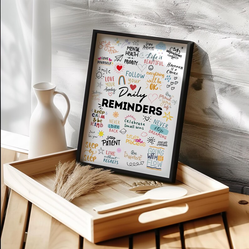 May include: A black framed poster with a white background and colourful handwritten text. The text includes phrases such as "Stay Present", "Mental Health is a Priority", "Love Yourself", "Follow Your Daily Reminders", "Keep Calm and Be Kind", "Never Stop Dreaming", "Live Without Regrets", and "Going With the Flow".