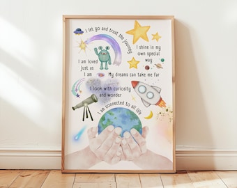 May include: A framed art print with a whimsical space theme. The artwork features a rocket, stars, a telescope, and a planet held in hands. Text includes phrases like "I am loved" and "I am connected to all life."