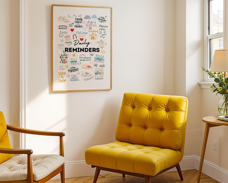 May include: A framed white poster with colourful handwritten text that reads "Daily Reminders" and includes words like "love", "follow", "patient", "never", "keep calm", "be kind", "live without regrets", and "going with the flow". The poster is hanging on a white wall above a yellow armchair.
