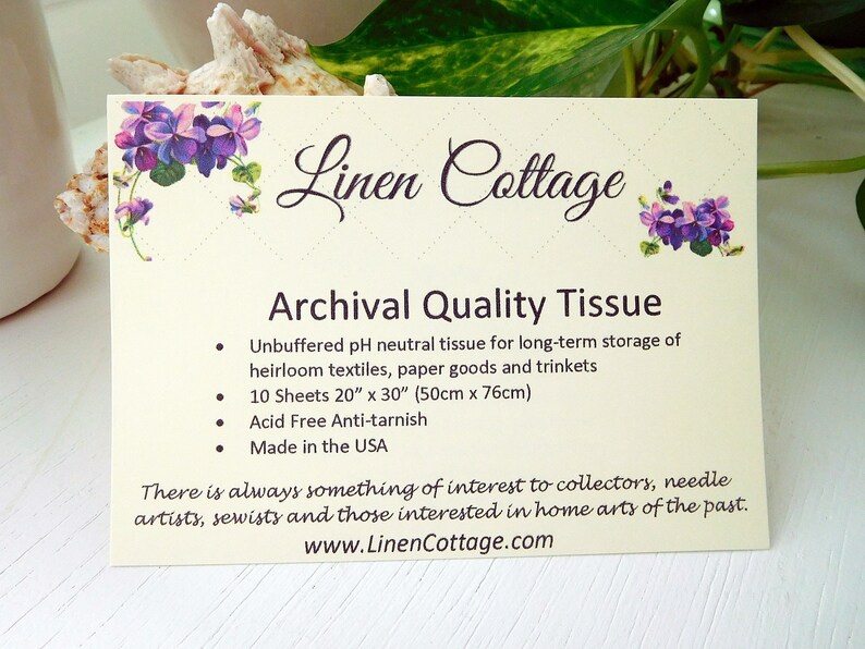 May include: A cream-colored card with the text "Linen Cottage" and "Archival Quality Tissue." The card features purple floral illustrations. The text describes the tissue as unbuffered, acid-free, and ideal for storing textiles and paper goods. The card is made in the USA.