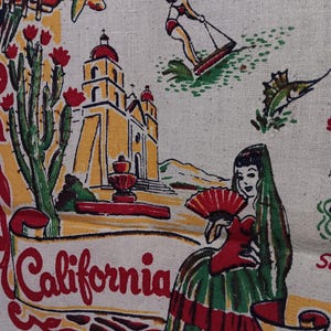May include: A beige fabric featuring a colorful screen-printed map of California. The design includes a yellow mission building, a green cactus with red flowers, a person water skiing, a fish, and a person holding a red fan, with the text California.