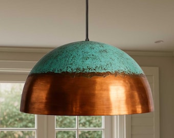 May include: A hanging pendant light with a copper and turquoise finish. The dome-shaped shade has a turquoise top and a copper bottom. The light hangs from a black cord.