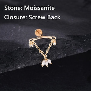 Könnte beinhalten: Goldfarbener Ohrring mit Schraubverschluss. Der Ohrring hat ein Ketten-Design mit drei hängenden weißen Edelsteinen unten. Der Text auf dem Bild lautet "Stone: Moissanite" und "Closure: Screw Back".