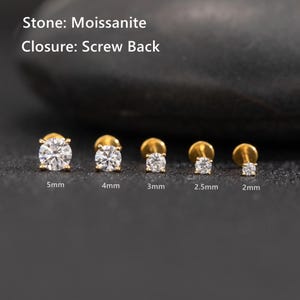 May include: A collection of gold-colored moissanite screw-back earrings in various sizes: 5mm, 4mm, 3mm, 2.5mm, and 2mm. The earrings are displayed on a dark surface. The text in the image reads "Stone: Moissanite" and "Closure: Screw Back."