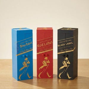 May include: Three decorative boxes in blue, red, and black, each featuring the Johnnie Walker logo and label. The blue box reads "Blue Label," the red box reads "Red Label," and the black box reads "Black Label."
