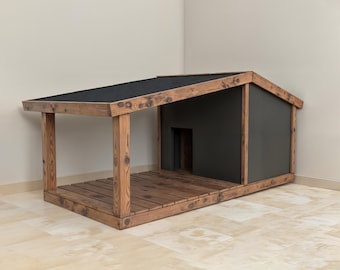 Può includere: Una cuccia per cani in legno con tetto nero e pareti grigio scuro. La cuccia ha un'area porticata con pavimento in legno e travi di supporto. La struttura è in legno tinto.