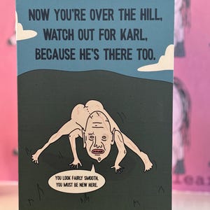 May include: A rectangular greeting card with a blue sky and dark hill background. It features a pale, hairless, four-legged creature labeled Karl. The text reads: NOW YOU'RE OVER THE HILL, WATCH OUT FOR KARL, BECAUSE HE'S THERE TOO. YOU LOOK FAIRLY SMOOTH, YOU MUST BE NEW HERE.