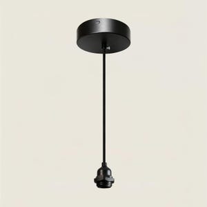 May include: A matte black pendant light fixture featuring a circular ceiling canopy, a thin vertical cord, and a threaded light bulb socket at the base. The hardware is finished in a solid black color, providing a clean and functional design.