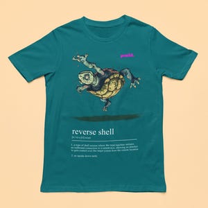 May include: Teal t-shirt with a cartoon illustration of a turtle flipped upside down. The text "reverse shell" is printed below the image with a definition of the term.