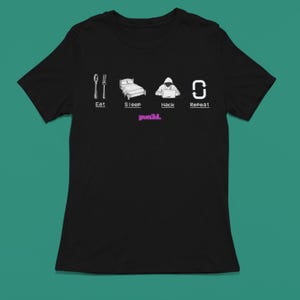 May include: Black t-shirt with a white graphic of a person in a hoodie sitting at a computer with the text "Eat, Sleep, Hack, Repeat" and the word "pwn3d." in pink below the graphic.
