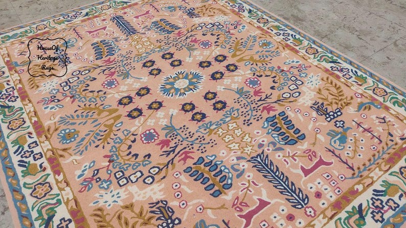 Peut inclure: Tapis rectangulaire &agrave; motifs floraux dans les tons p&ecirc;che, bleu et cr&egrave;me. Le tapis pr&eacute;sente un motif de m&eacute;daillon central entour&eacute; de fleurs et de feuilles stylis&eacute;es. La bordure pr&eacute;sente un motif floral r&eacute;p&eacute;titif.