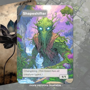 Op de afbeelding: Een fantasy art kaart met een groene, humanoïde creatuur met blauwe ogen, getiteld "Shapeshifter". De kaart bevat de tekst "Changeling (This token has all creature types.)" en "1/1". Een tweede kaart met een zwarte lotusbloem is zichtbaar.