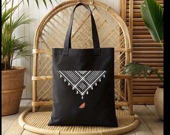 May include: Black tote bag with a white and black geometric design and a watermelon slice graphic. The bag has two black handles and is made of a sturdy fabric. The tote bag is suitable for carrying groceries or personal items.