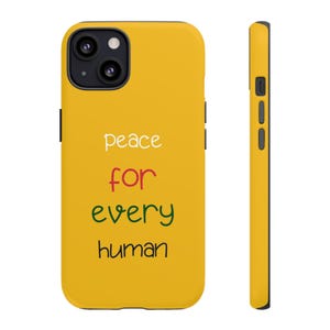 Könnte beinhalten: Eine gelbe Handyhülle mit den Worten "peace for every human" in Weiß, Rot, Grün und Schwarz. Die Hülle hat eine schwarze Kameralinse und Knöpfe an der Seite.