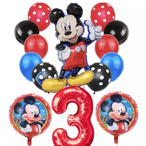 May include: A red number 3 balloon, two red and black polka dot balloons, two blue balloons, two red balloons, two black balloons, and two Mickey Mouse balloons. The Mickey Mouse balloons are red and black with a white face and black eyes. The balloons are arranged in a circle around the number 3 balloon.