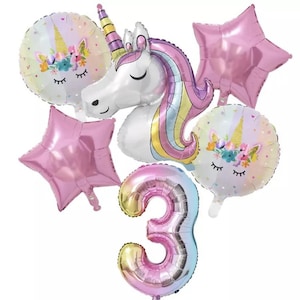 May include: A set of unicorn-themed party balloons, including a large unicorn head balloon, two star-shaped balloons, two round balloons with unicorn faces, and a large number 3 balloon. The balloons are pink, white, and yellow.