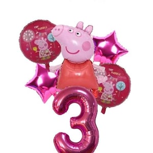 May include: A set of pink foil balloons, including a large number 3, star-shaped balloons, and round balloons featuring a cartoon pig. The pig-shaped balloon is the central focus, with a red dress. The balloons are for a birthday celebration.