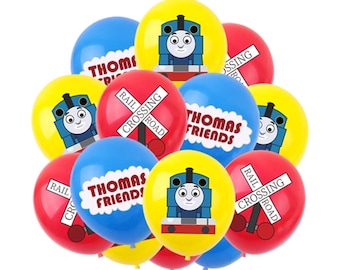 Może przedstawiać: Grupa kolorowych balonów z nadrukiem Thomasa Lokomotywy i jego przyjaciół. Balony są w kolorze czerwonym, żółtym, niebieskim i białym. Na niektórych balonach widnieje napis "Thomas Friends" i "Rail Crossing".